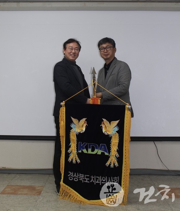 양성일 회장(왼쪽)이 전용현 신임 회장에게 경북치 깃발을 건네고 있다.