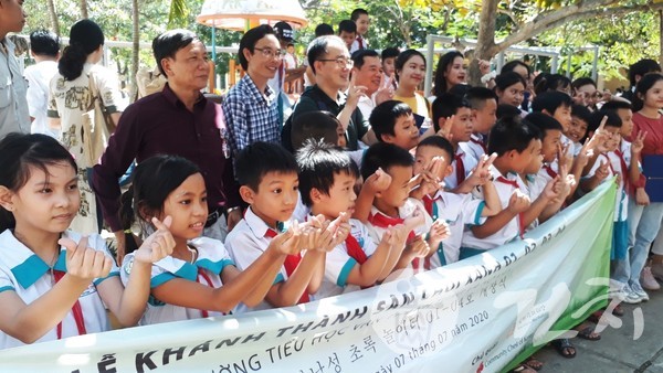 개장식을 위해 학교를 찾아온 손님들을 반기고 있는 반탄뚱 초등학교 학생들.