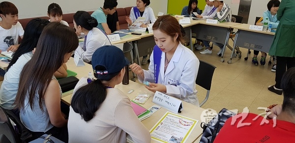 치위생학과 학생들이 외국인 학생들에게 구강용품 사용법을 가르치고 있다.