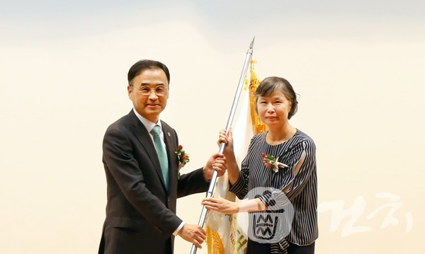 부산대 차정인 총장(왼쪽)이 조봉혜 병원장에게 부산대치과병원 깃발을 전달하고 있다.
