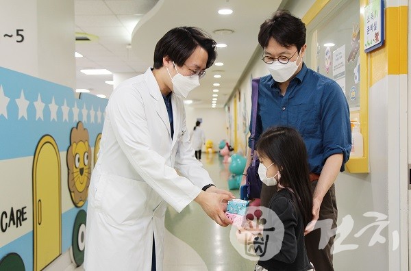 지난 4일 어린이날을 앞두고 서울대치과병원 소아치과 김현태 교수(왼쪽)가 어린이 환자에게 선물을 전달하고 있다.